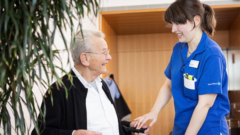Älterer Patient im Gespräch mit Physiotherapeutin